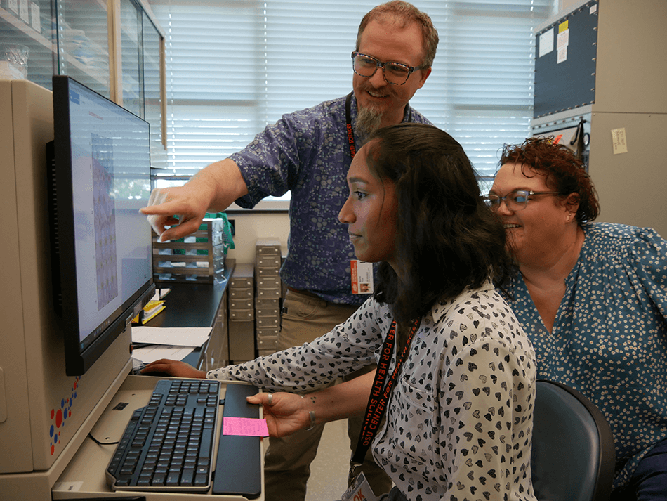 Dr. Bart Ford with 2 other assistances looking at a monitor.