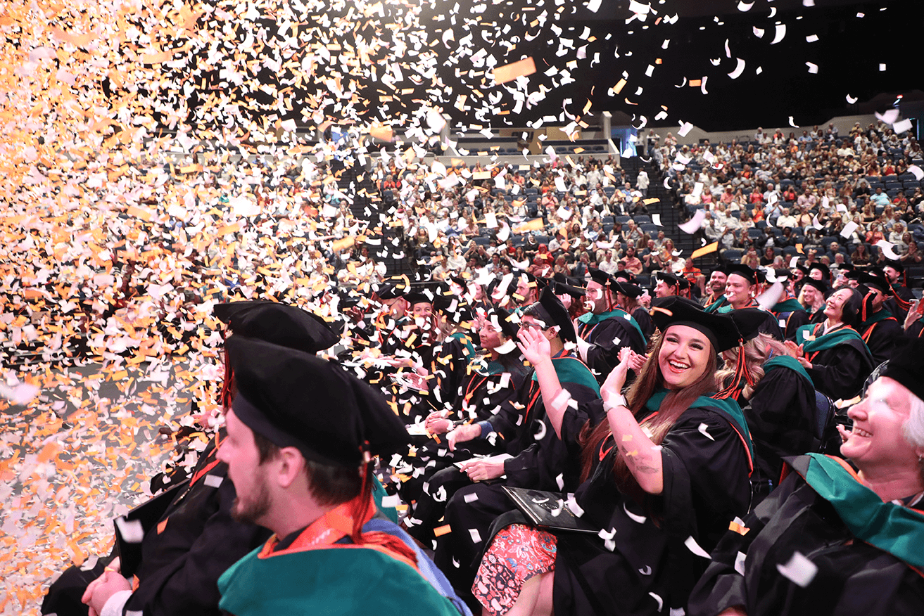 Medical students celebrating amidst confetti at their commencement ceremony in 2023.
