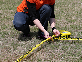 student setting up caution tape