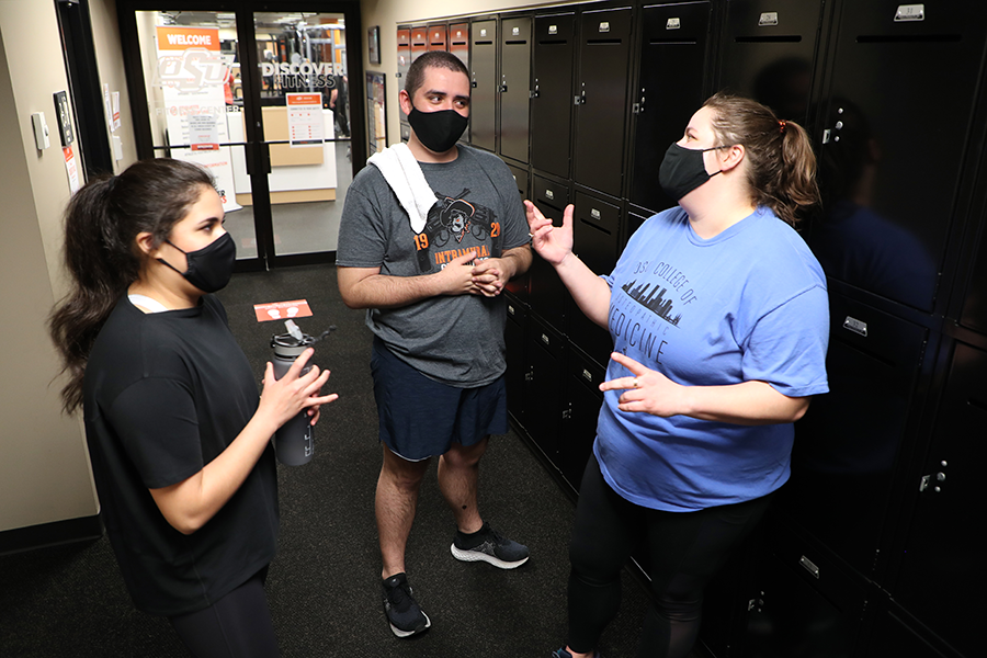 Three CHS students standing in the OSU-CHS Wellness locker rooms talking